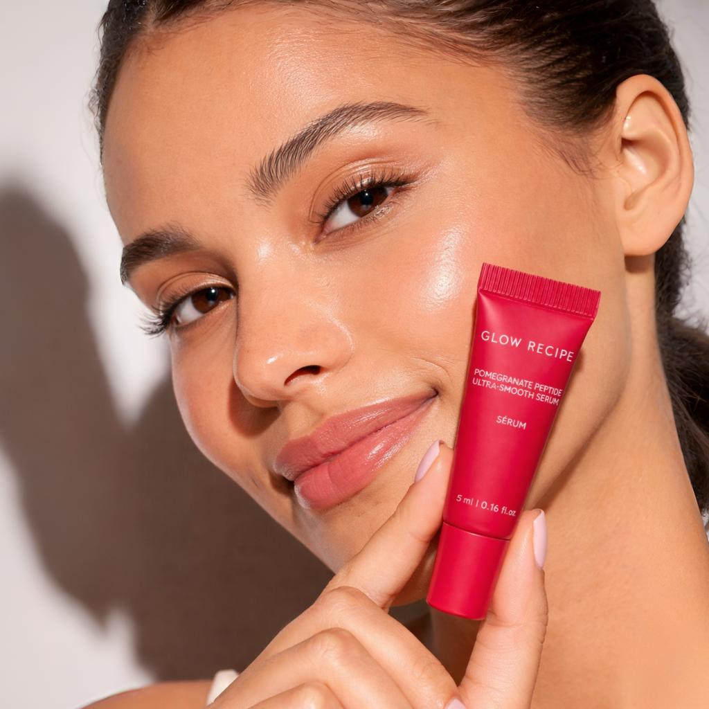 Model applying Glow Recipe pomegranate peptide serum for radiant smooth and youthful skin